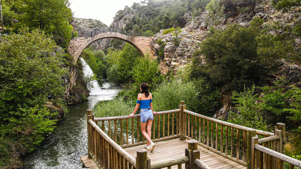 vista aérea del puente histórico y la cascada, el cañón y el agua que fluye desde el puente, el puente con hermosa vista en el bosque, la vista de la cascada con el puente, el puente frigio, la mujer observando la vista, la mujer observando la cascada - europe high angle view waterfall water fotografías e imágenes de stock