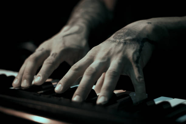 istock Tattooed mans hands on the keyboard of a piano 1363667155