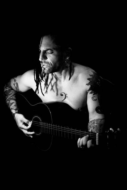 istock Man playing guitar and singing shirtless 1363667164