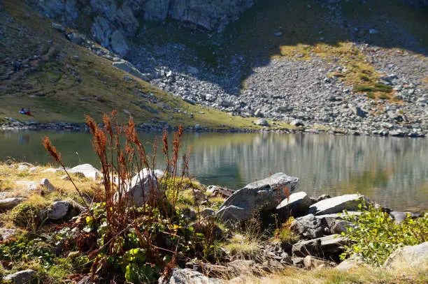 Photo of mountain lake on a sunny day, mountains are reflected in the water