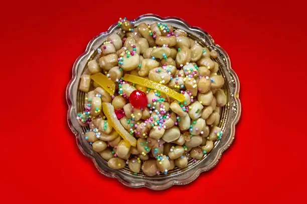 Struffoli, typical Neapolitan pastry consisting of many small balls of dough (realized with flour, eggs, lard, sugar, anise liqueur), fried in oil and wrapped in warm honey. Decorated with colored sprinkles.