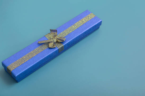 istock Gift blue box on a turquoise background. Holiday gifts closeup with copy space 1363675429