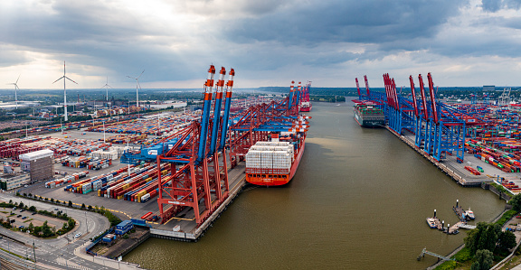 Cranes and trucks at the port are carrying goods