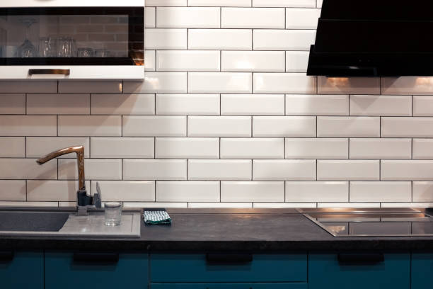 istock Kitchen design with white brick tiles and dark countertops. Home modern interior 1363677295