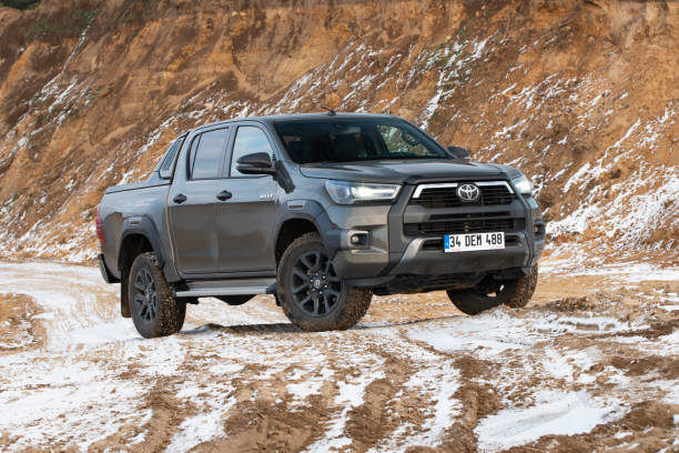 Toyota Hilux on a gravel road Zdiar, Slovakia - 9th January, 2022: Toyota Hilux Invincible stopped on a gravel road in winter scenery. The Hilux is one of the most popular pick-up vehicles in the world. toyota hilux stock pictures, royalty-free photos & images