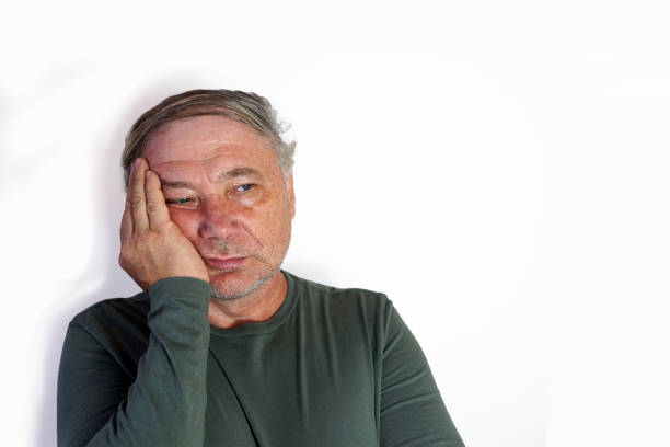 istock A sad old man holding a sore tooth with his hand 1363677685