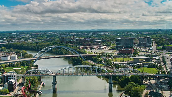 Aerial shot of bridges across the Cumberland River in Nashville, Tennessee on a cloudy afternoon in Fall.