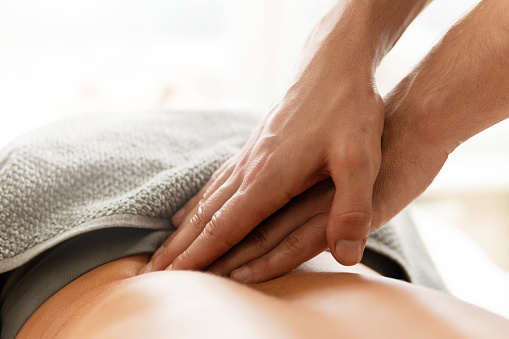 Closeup of masseur man's hands during back massage for his woman client