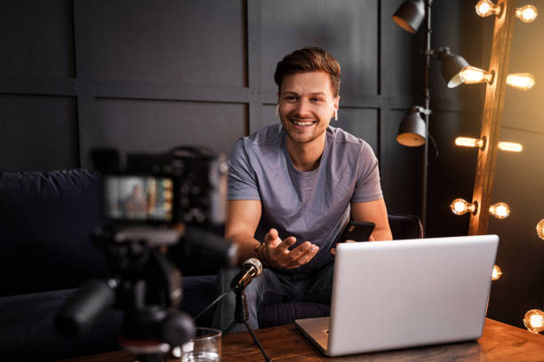 istock Young smiling blogger is sitting in front of a laptop 1363688556