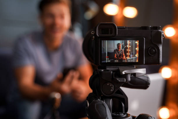 istock Bearded blogger sitting on a sofa is looking into a camera and smiling 1363689349