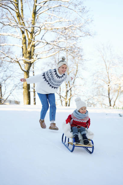istock Mother and her cute little son having on a sledding hill 1363691435