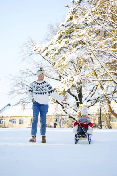 istock Mother and her cute little son having on a sledding hill 1363691457