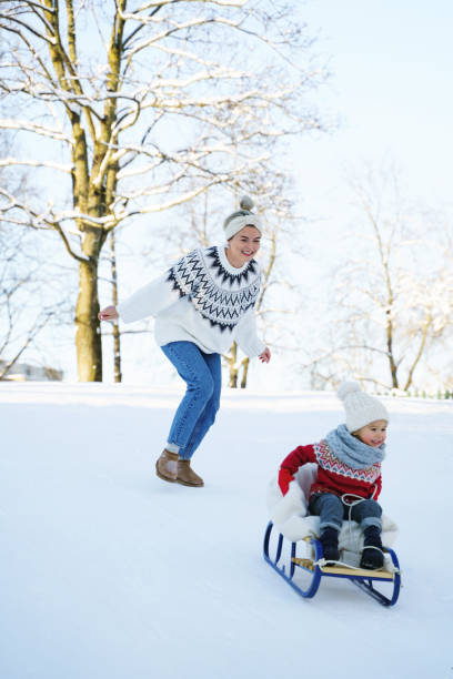 istock Mother and her cute little son having on a sledding hill 1363691482