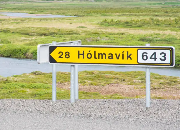 Sign near the road pointing towards town of Holmavik in west Icleand