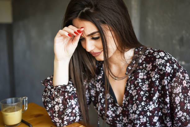 istock Attractive young woman suffering with a headache at home 1363694831