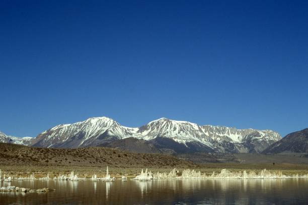 On a cold spring day the lake and its tufa towers are flanked by the snow-capped Sierra Nevada Mountains on its eastern side.
