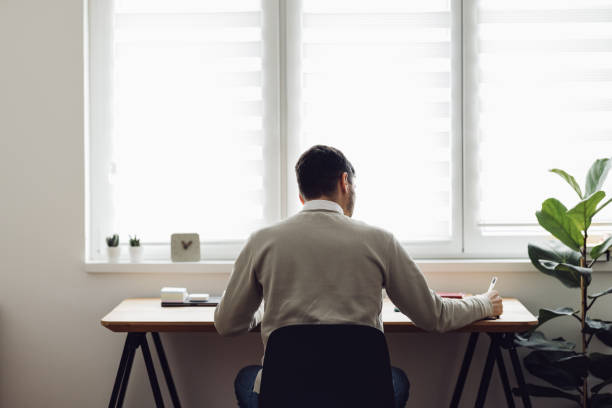 istock Home Office: Man Sitting at the Table and Writing 1363697778