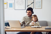 Home Office: Man Having a Video Call and Holding a Kid