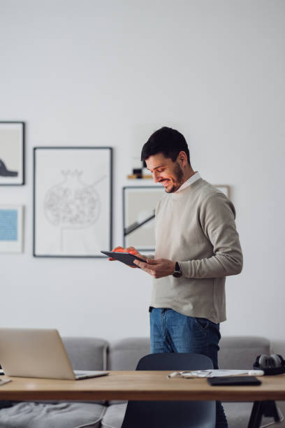 home office: un homme utilisant une tablette numérique - digital tablet student studying learning photos et images de collection