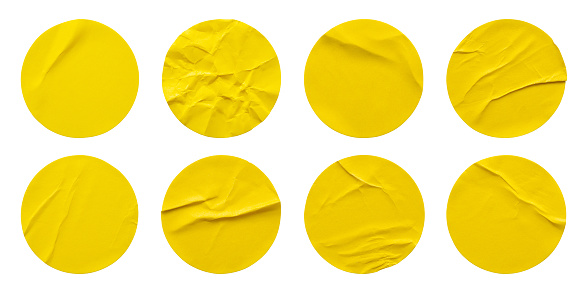 Etiqueta adhesiva de papel redondo amarillo con un conjunto aislado sobre fondo blanco photo