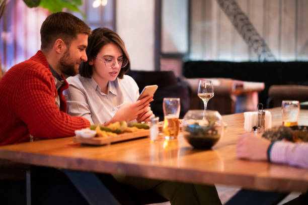 istock Young couple using a smartphone together at the restaurant 1363698652