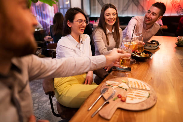 istock Smiling young group of people while toasting with their drinks 1363698680