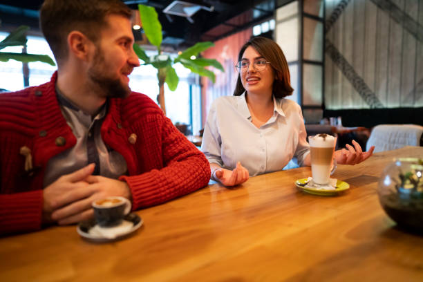 istock Young couple enjoying coffee while talking at the cafe 1363698721
