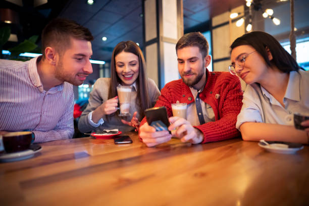 istock Friends having fun and using a phone together at the coffee shop 1363698742