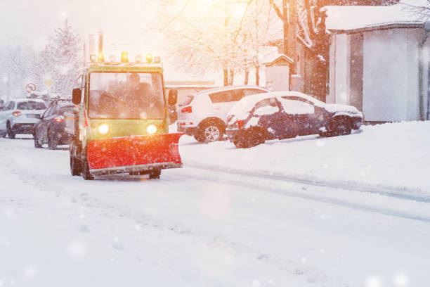 istock Tractor is sweeping snow in snowfall.Tractor with bulldozer cleans sidewalk from snow in winter.Little red tractor with snowplow in a motion removing snow .Reduced visibility in snow flurries. 1363698820