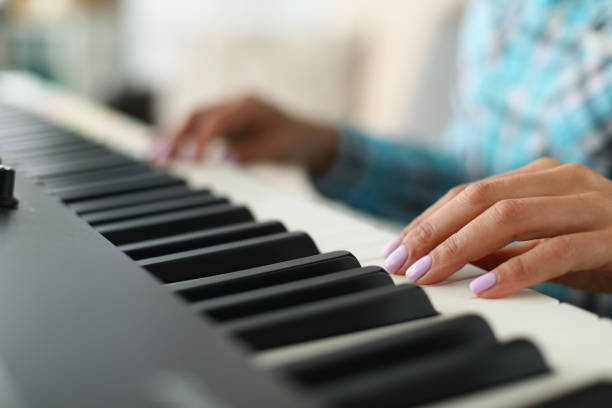 istock Womans hand touching white and black keyboards on piano 1363699021