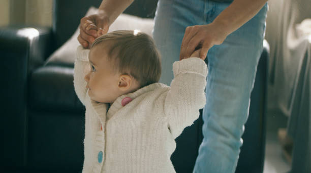 istock Childcare. Baby's first steps with mother at home. 1363699090