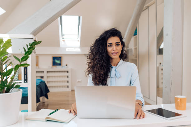 istock Mid adult woman working from her home office 1363701477