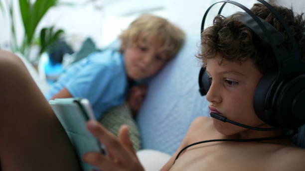 istock Child plays video-game wearing headset with mic connected online gaming 1363708371