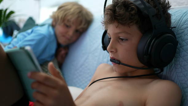 istock Child plays video-game wearing headset with mic connected online gaming 1363708440