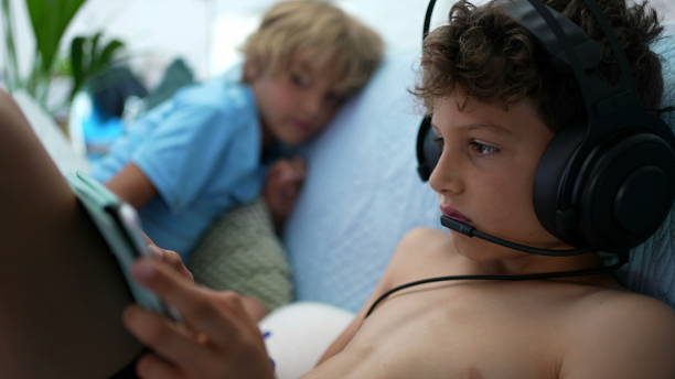 istock Child plays video-game wearing headset with mic connected online gaming 1363709174