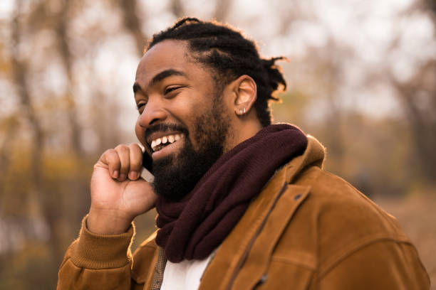 istock Happy African American man talking on phone while walking in autumn park. 1363710185