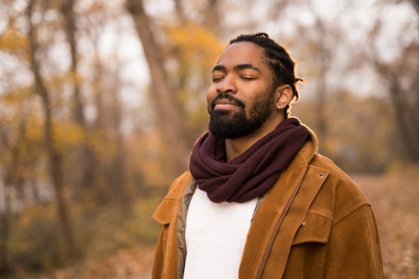 ruhiger junger mann, der in der natur meditiert. - geschwollene-augen stock-fotos und bilder