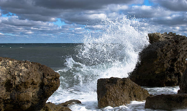 wave breaking over the big stone stock photo