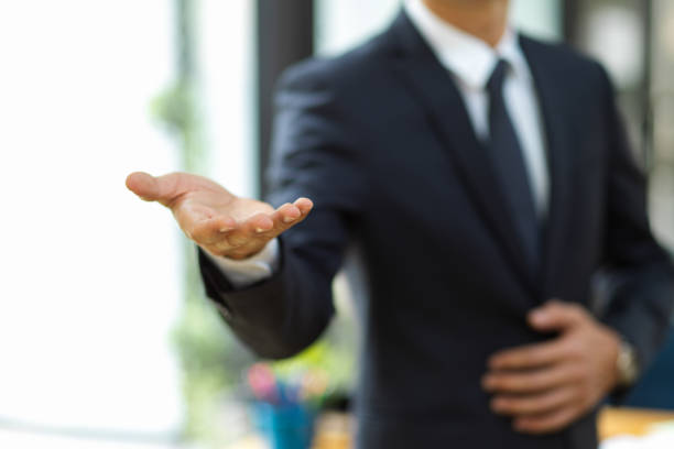 istock A businessman in formal suit extending hand for handshake at camera. 1363717618