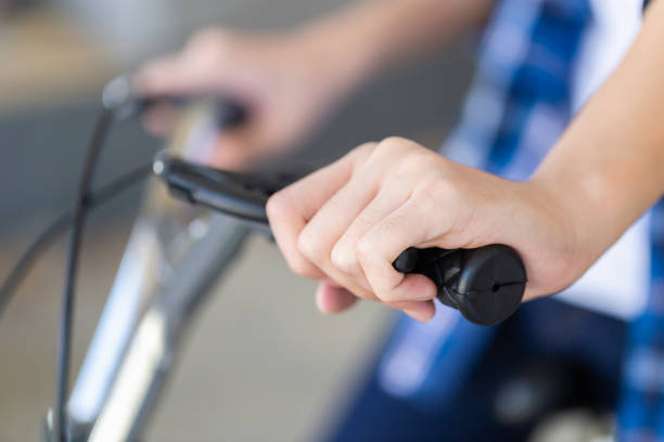 Boy hand holding a bicycle brake. Kid sitting on a bicycle using the handbrake