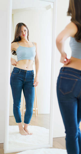 istock asian woman looks in mirror 1363726935