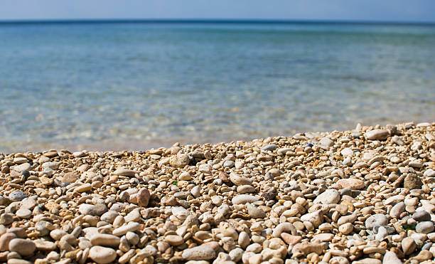 pebbles and blue water, beach in summer stock photo