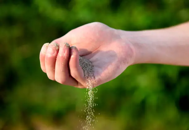 Sand in the Hand on the Nature Background closeup