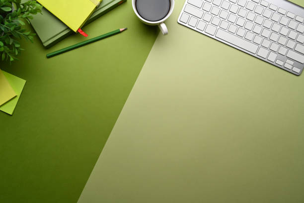 istock Top view wireless keyboard, coffee cup and stationery on green background. 1363733123