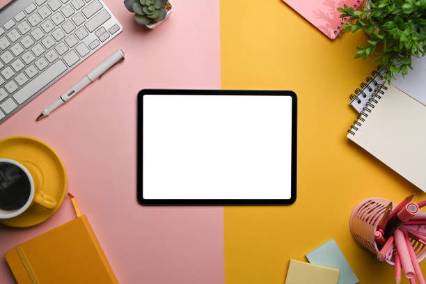 istock Top view digital tablet, coffee cup and supplies on colorful background. 1363733130