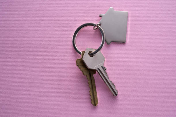 istock Silver house shaped keychain and key isolated on pink 1363734092