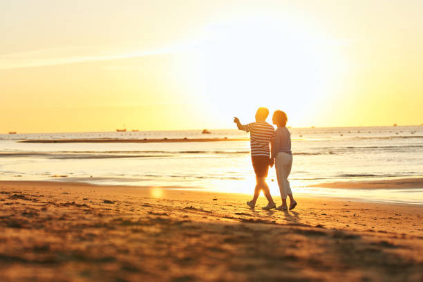 istock Elderly couple walking on the beach 1363734766