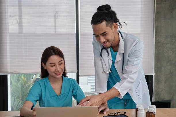 istock Two uniformed young doctors work in medical clinic office. 1363734803