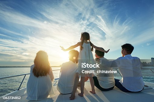 istock Happy family aboard a yacht out to sea 1363734852