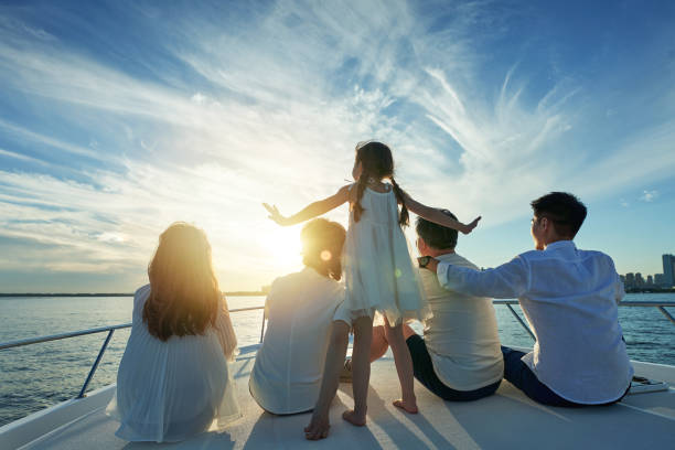 Família feliz a bordo de um iate para o mar - foto de acervo